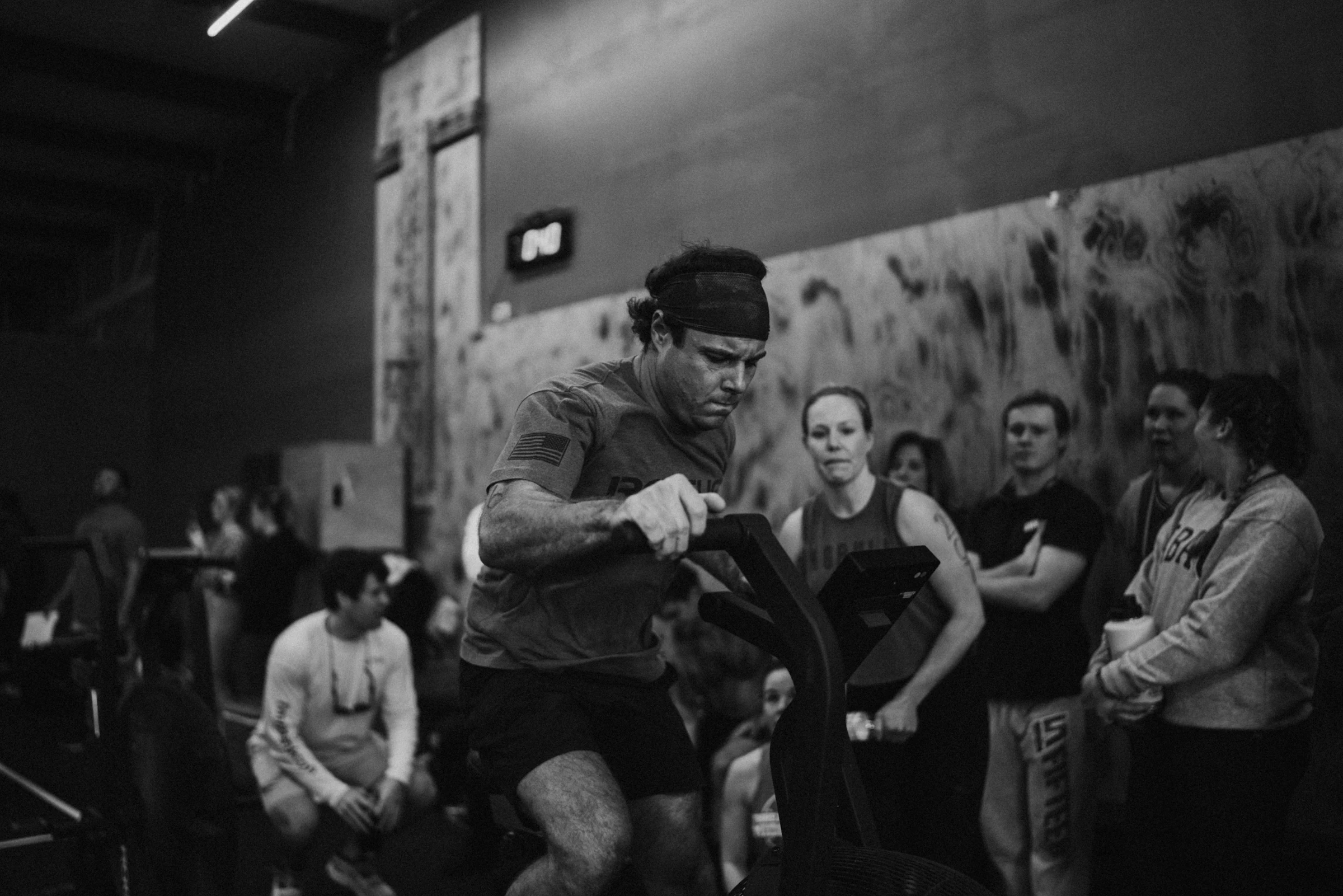 Una clase de un box reunida alrededor de un atleta que termina su serie.